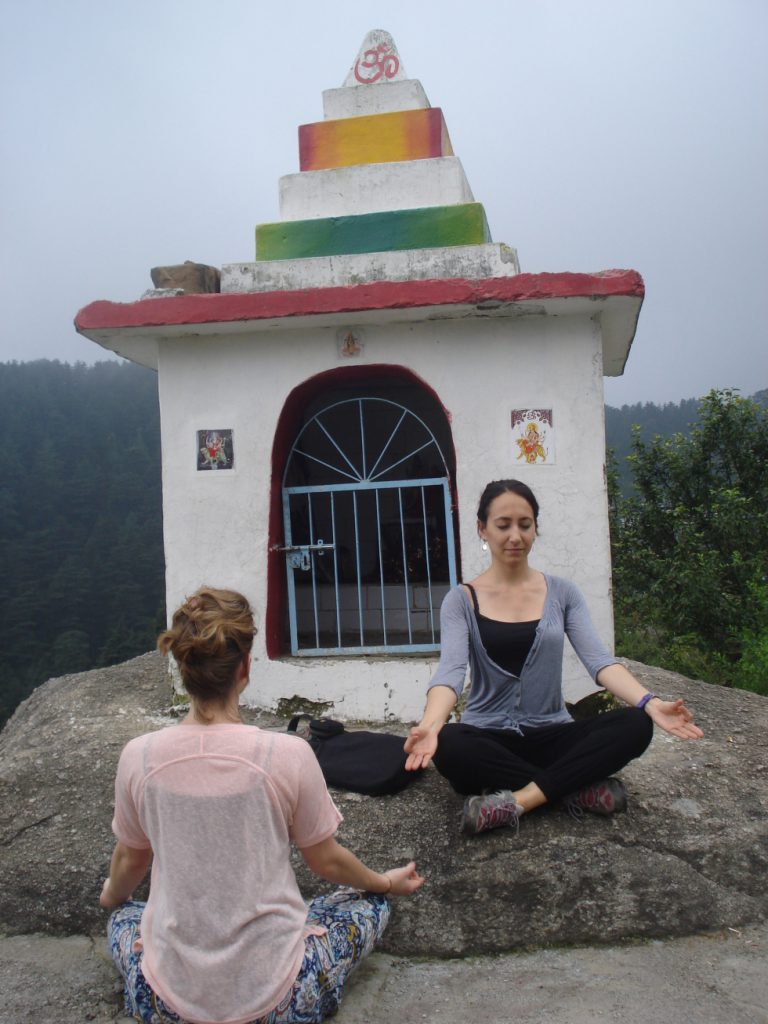 deux femmes se faisant face en position classique de yoga